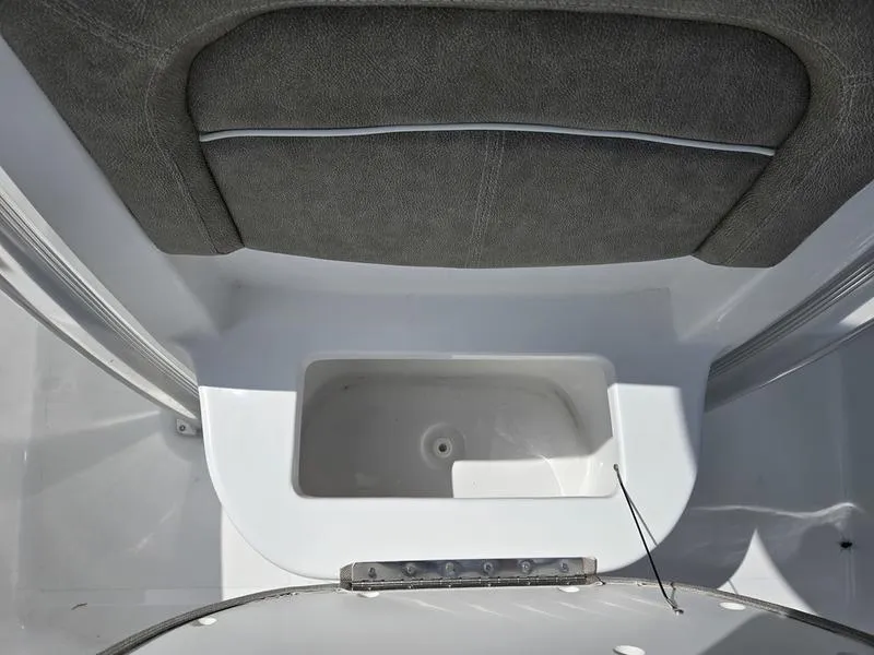 Slide: The Image of 2025 Sea Hunt Ultra 219 boat interior with cushioned seating and storage compartment. - 5