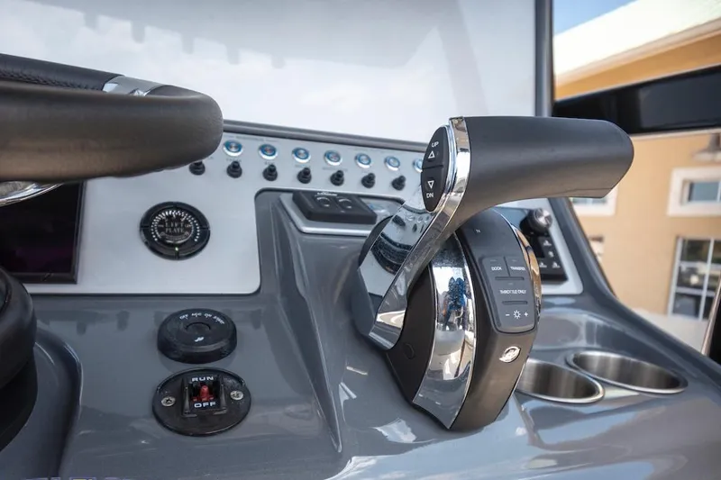 Slide: The Image of Control panel of 2023 ShearWater 260 Carolina SS boat, featuring throttle and steering wheel. - 10