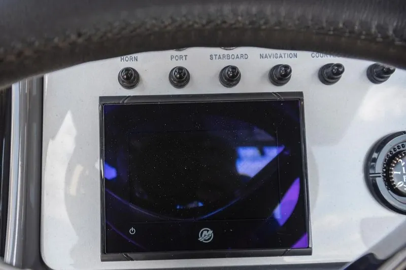 Slide: The Image of Dashboard of 2023 ShearWater 260 Carolina SS with control switches and display screen. - 18