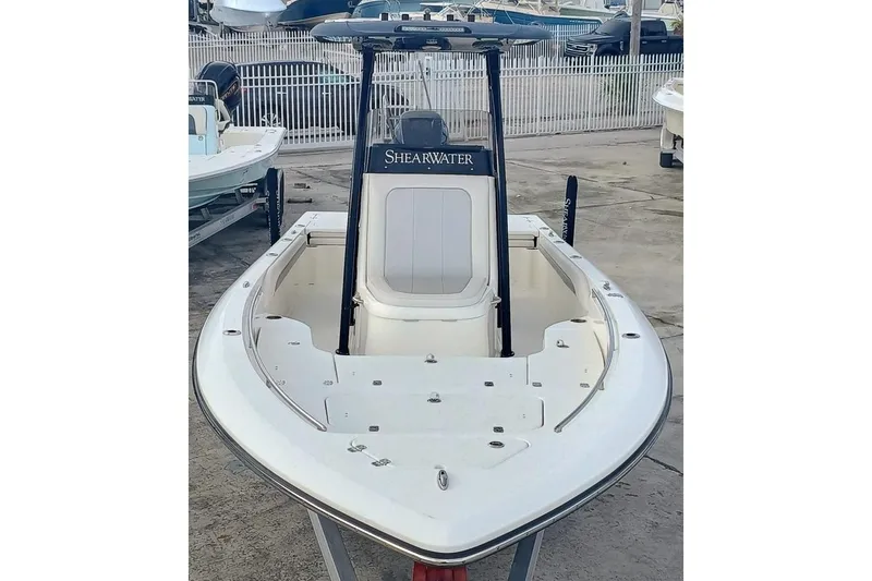Slide: The Image of 2023 ShearWater 260 Carolina SS boat, white deck, sleek design, parked at marina. - 2