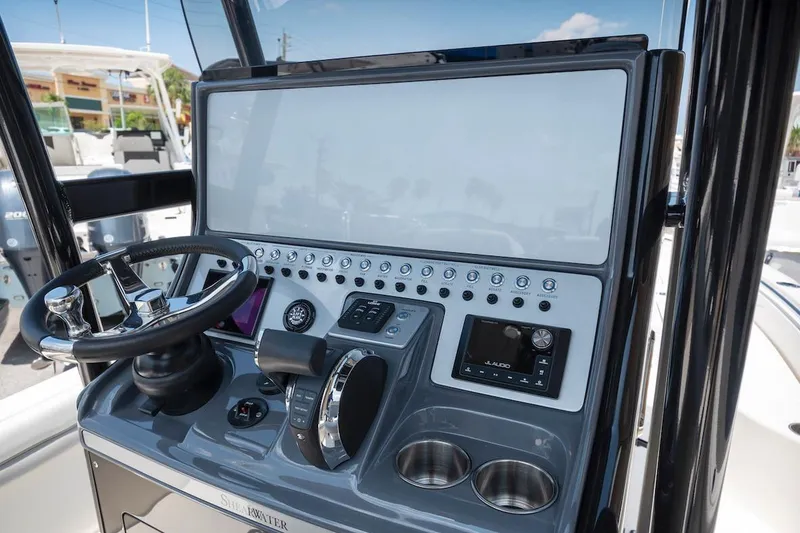 Slide: The Image of 2023 ShearWater 260 Carolina SS boat console with steering wheel and controls. - 9