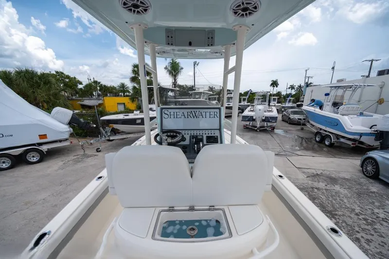 Slide: The Image of 2023 ShearWater 260 SS boat interior with console, parked in a marina. - 24