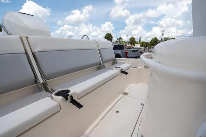 Slide: The Image of 2023 ShearWater 260 SS boat interior with cushioned seating and cup holders under a blue sky. - 7