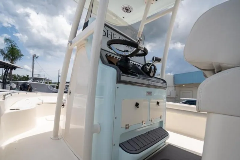 Slide: The Image of 2023 ShearWater 260 SS boat interior with steering console, under a cloudy sky. - 9