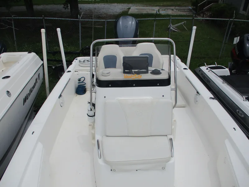 Slide: The Image of 2007 Century 2202 boat interior with console and seating, docked outdoors. - 2