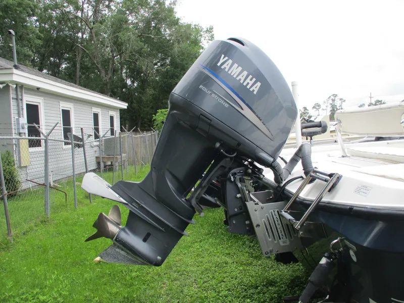 Slide: The Image of Outboard motor on a 2007 Century 2202 boat, parked on grass near a house. - 8