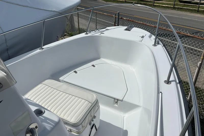 Slide: The Image of 1997 Boston Whaler Outrage 20 boat interior with white seating and storage area. - 2