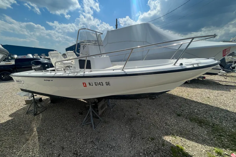 Slide: The Image of 1997 Boston Whaler Outrage 20 boat on display under a partly cloudy sky. - 3