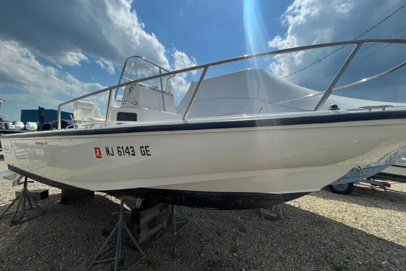 Slide: The Image of 1997 Boston Whaler Outrage 20 boat on stands under a cloudy sky. - 4