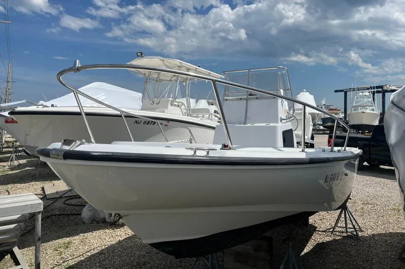 Slide: The Image of 1997 Boston Whaler Outrage 20 boat on display under a partly cloudy sky. - 5