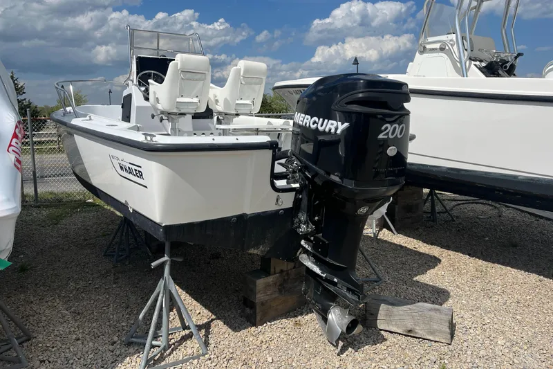 Slide: The Image of 1997 Boston Whaler Outrage 20 boat with Mercury 200 engine on display outdoors. - 7