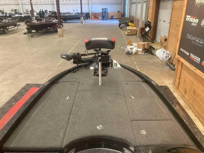 Slide: The Image of 2022 Caymas CX 21 PRO boat in a showroom, featuring a spacious deck and seating. - 8