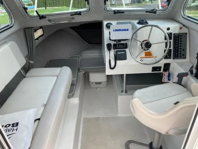 Slide: The Image of 2016 Parker 2120 Sport Cabin interior with steering wheel, seating, and navigation equipment. - 2