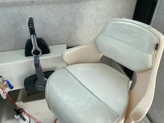 Slide: The Image of Captain's chair and controls in a 2016 Parker 2120 Sport Cabin boat. - 4
