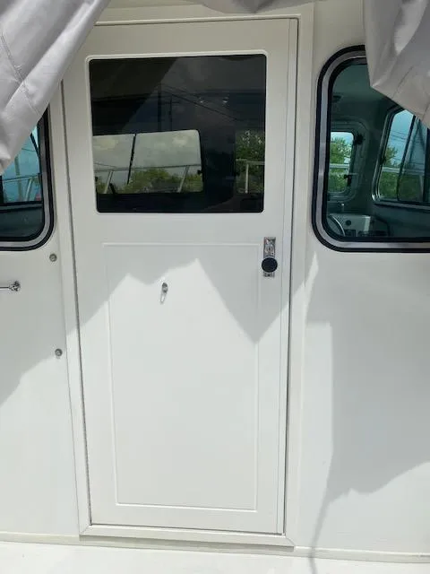 Slide: The Image of 2016 Parker 2120 Sport Cabin boat door with window, white exterior. - 6