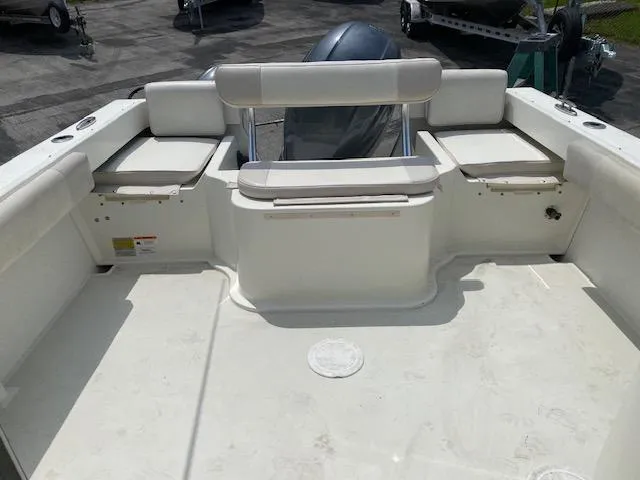 Slide: The Image of 2016 Parker 2120 Sport Cabin boat interior with seating and motor view. - 7