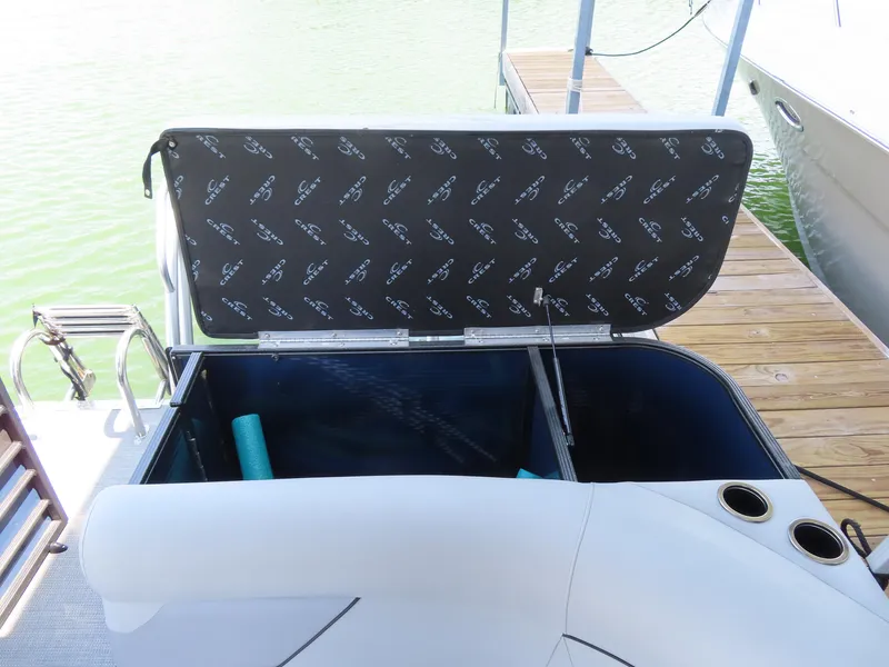 Slide: The Image of 2022 Crest Classic LX 220 boat storage compartment open at dock. - 11