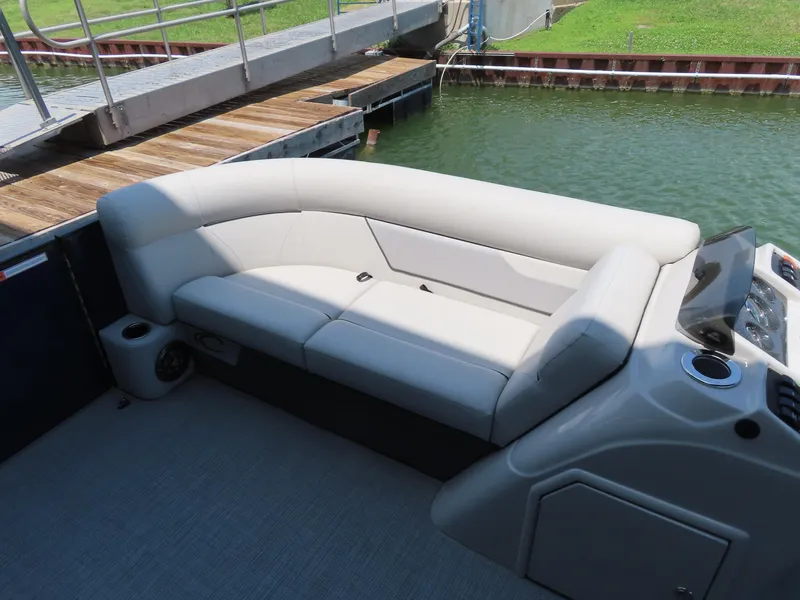 Slide: The Image of 2022 Crest Classic LX 220 boat interior with beige seating and console. - 9