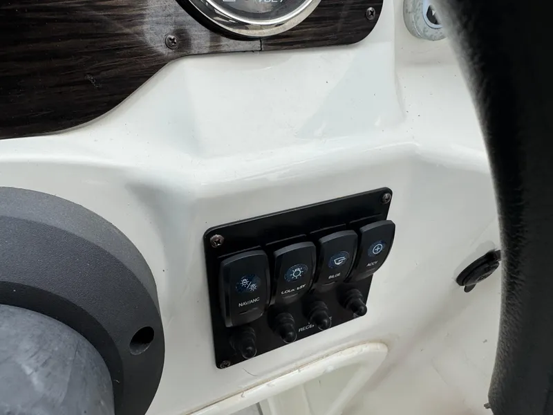 Slide: The Image of Control panel of a 2019 Stingray 191 DC boat with switches and dials. - 11