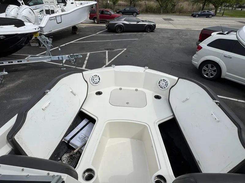 Slide: The Image of 2019 Stingray 191 DC boat interior with storage compartments in a parking lot. - 16
