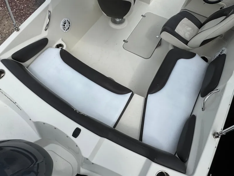 Slide: The Image of 2019 Stingray 191 DC boat interior with white and black seating and steering console. - 4