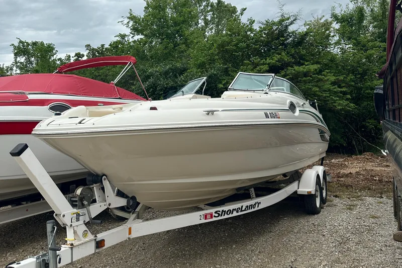 Slide: The Image of 2001 Sea Ray 240 Sundeck boat on trailer, parked outdoors near trees. - 1