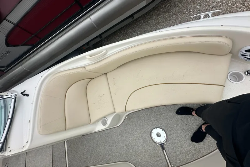 Slide: The Image of 2001 Sea Ray 240 Sundeck boat interior with beige seating and carpeted floor. - 10