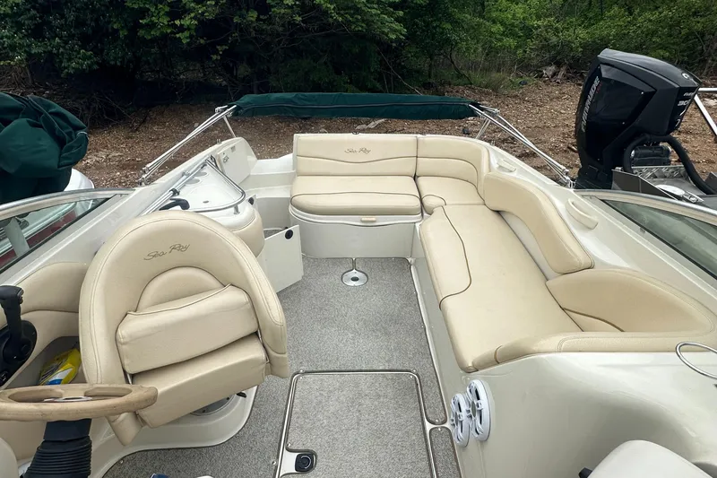 Slide: The Image of 2001 Sea Ray 240 Sundeck boat interior with beige seating and steering wheel. - 13