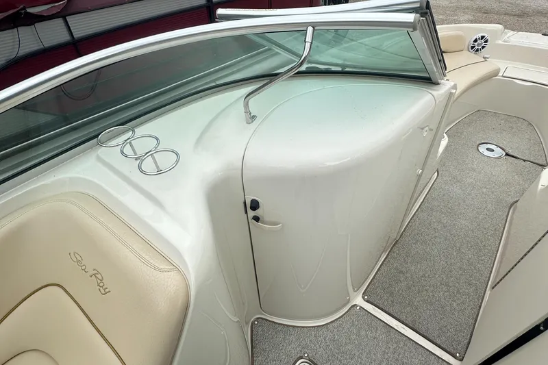Slide: The Image of 2001 Sea Ray 240 Sundeck interior with beige seating and cup holders. - 14