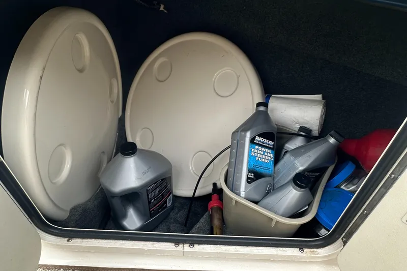 Slide: The Image of Storage compartment of 2001 Sea Ray 240 Sundeck with oil containers and supplies. - 20