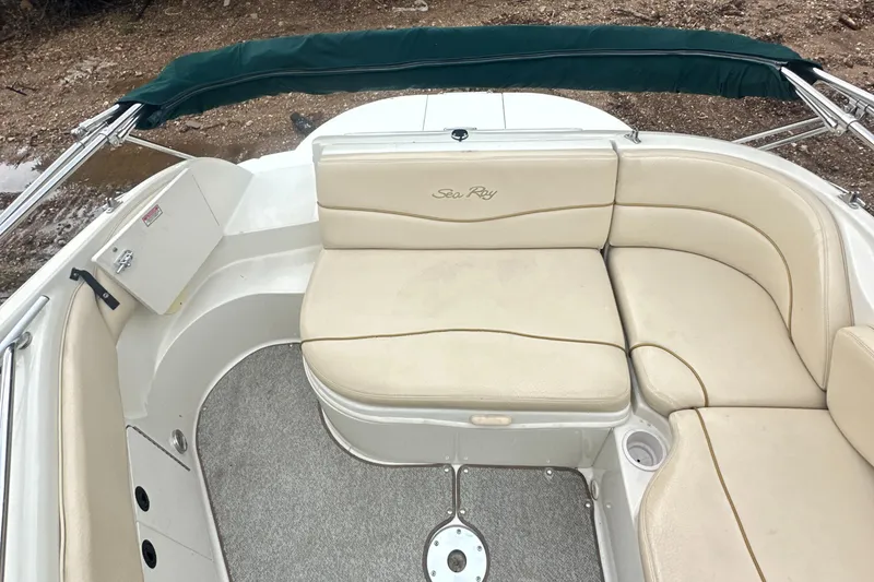 Slide: The Image of 2001 Sea Ray 240 Sundeck boat interior with beige seating and green canopy. - 23