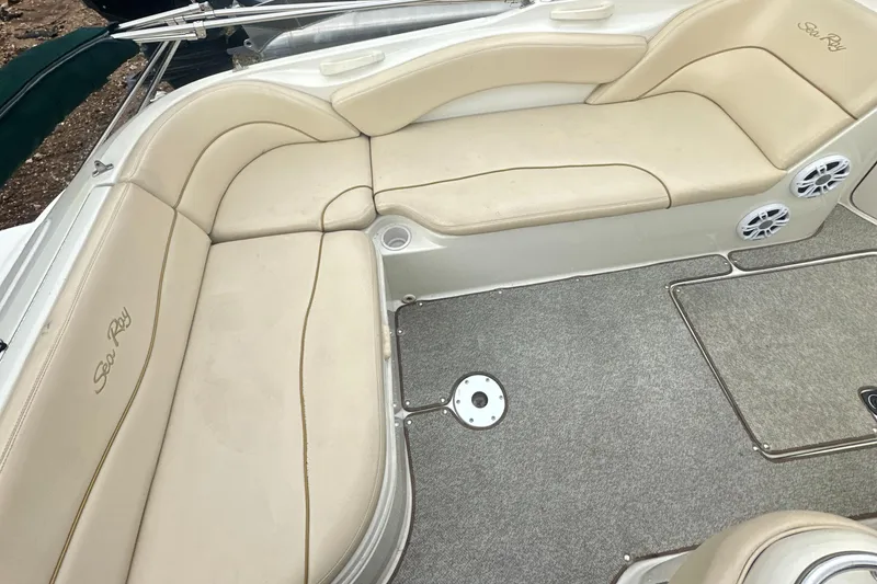 Slide: The Image of 2001 Sea Ray 240 Sundeck interior with beige seating and carpeted floor. - 24