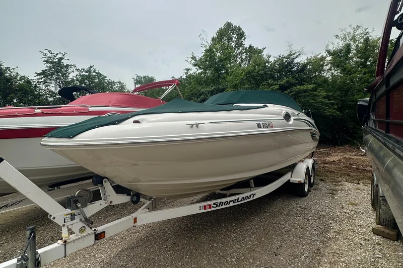 Slide: The Image of 2001 Sea Ray 240 Sundeck boat on trailer, covered, parked outdoors. - 27