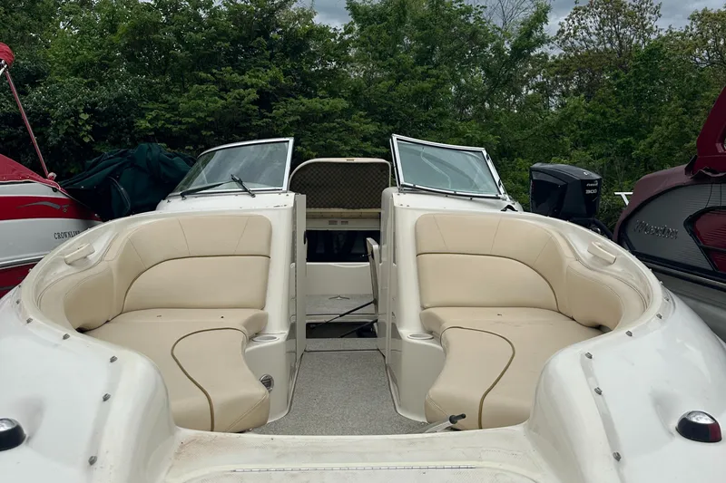Slide: The Image of 2001 Sea Ray 240 Sundeck boat with open seating and lush greenery in the background. - 3