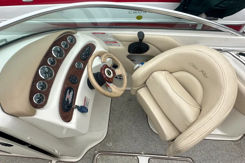 Slide: The Image of 2001 Sea Ray 240 Sundeck boat interior with beige seating and dashboard controls. - 6