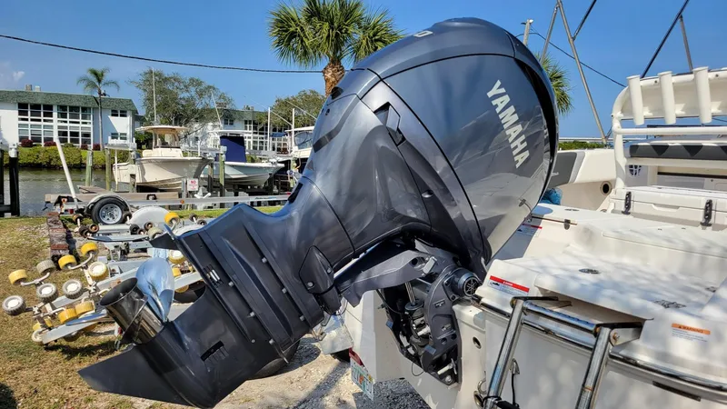 Slide: The Image of 2024 Robalo R180 Center Console with Yamaha outboard motor, docked near palm trees. - 5