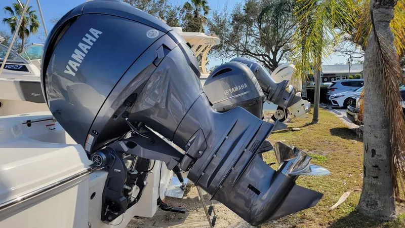 Slide: The Image of 2024 Robalo R180 Center Console with Yamaha outboard motors, parked outdoors. - 6