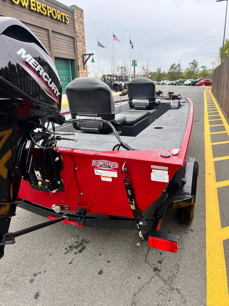 Slide: The Image of 2025 Tracker Panfish 17 boat with Mercury engine, parked outside a powersports store. - 2