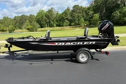 The Image of 2025 Tracker Panfish 17 boat on trailer, parked outdoors with trees in background. - 0