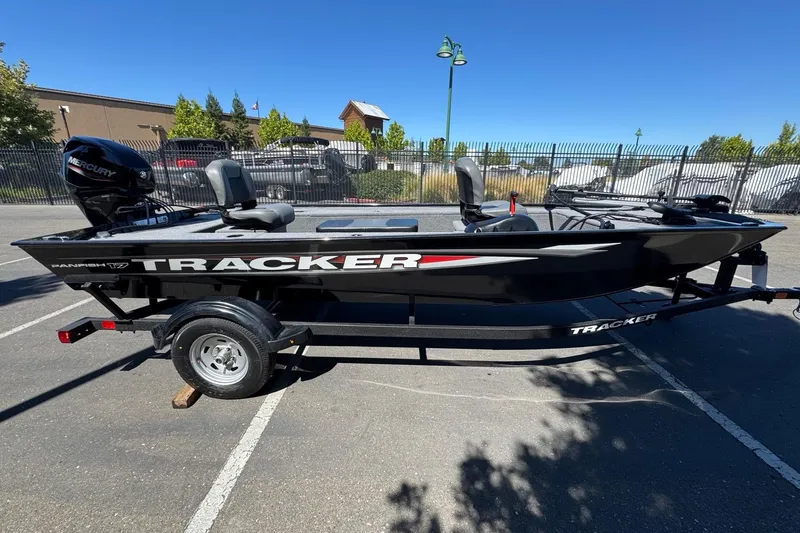 Slide: The Image of 2025 Tracker Panfish 17 boat on trailer, parked outdoors under clear blue sky. - 5