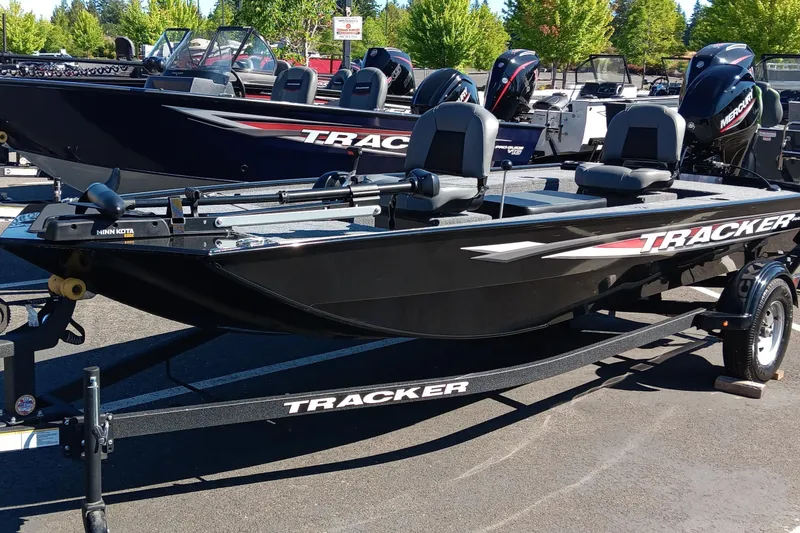 Slide: The Image of 2025 Tracker Panfish 17 boat on trailer, parked outdoors, featuring sleek black design. - 2