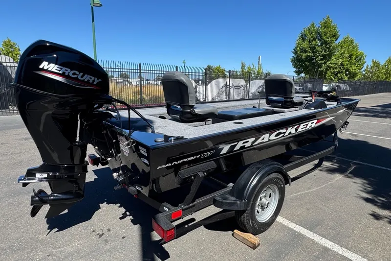 Slide: The Image of 2025 Tracker Panfish 17 boat with Mercury engine, parked outdoors on a sunny day. - 4