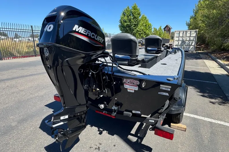 Slide: The Image of 2025 Tracker Panfish 17 boat with Mercury engine, parked outdoors on a sunny day. - 3
