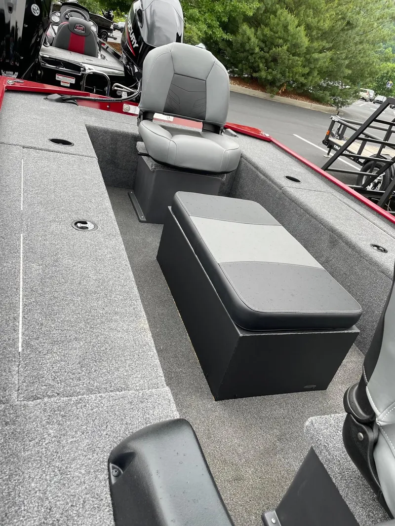 Slide: The Image of 2025 Tracker Panfish 17 boat interior with seating and storage, featuring gray upholstery and carpet. - 2