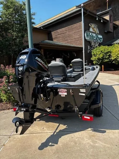 Slide: The Image of 2025 Tracker Panfish 17 boat with Mercury engine parked outside White River building. - 3