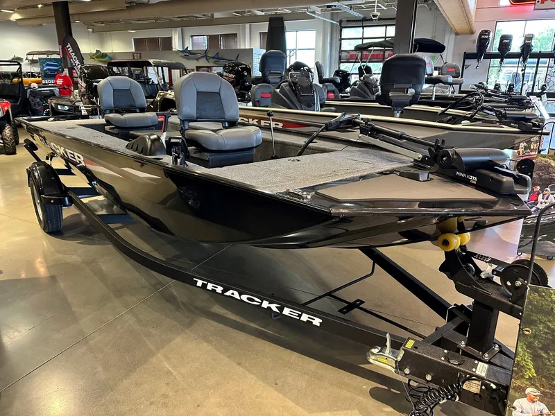The Image of 2025 Tracker Panfish 17 boat in showroom, featuring dual seats and sleek black design. - 0