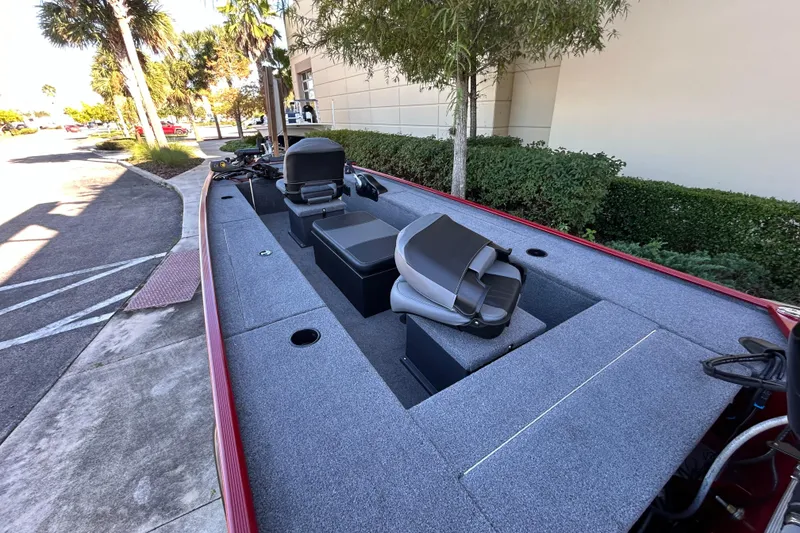 Slide: The Image of 2025 Tracker Panfish 17 boat with seating, parked outdoors near trees and a building. - 4