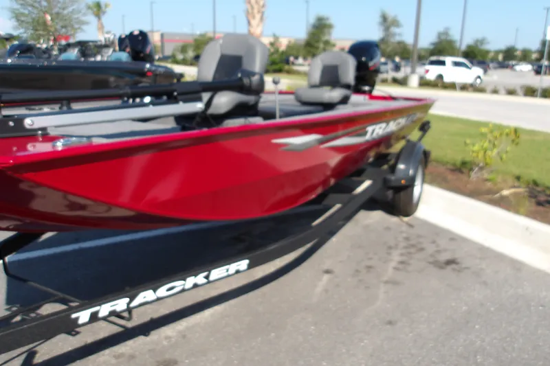 The Image of 2025 Tracker Panfish 17 boat in vibrant red on a trailer, parked outdoors. - 2