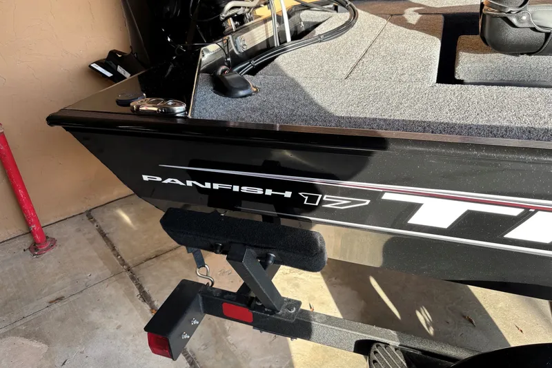 Slide: The Image of 2025 Tracker Panfish 17 boat on trailer, close-up view of side branding. - 11