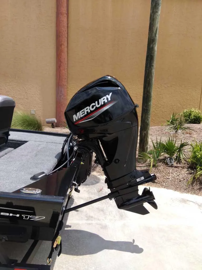 Slide: The Image of 2025 Tracker Panfish 17 boat with Mercury outboard motor, parked outdoors. - 4